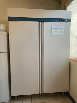 two refrigerators that are in a kitchen near a window