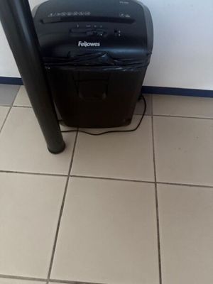 a black paper shredder sitting on the floor next to a black pole