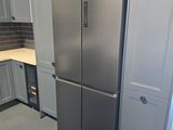 a refrigerator in the middle of a kitchen with white cabinets