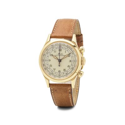 une image d'une montre en or avec un bracelet en cuir marron