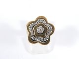 un gros plan d'une bague en or ornée d'une fleur en diamant