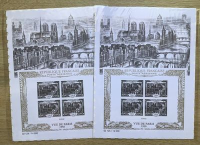 deux pages de timbres posées sur une table, avec une photo d'une ville