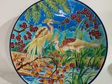 a plate with a painting of birds and flowers on it