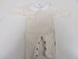 a white knitted baby romper with buttons on the front