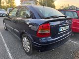 a blue car parked in a parking lot next to a red car