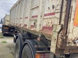 a dirty dump truck that is parked on the side of the road
