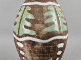 un vase marron orné de motifs verts et blancs