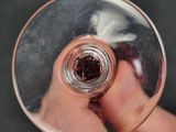 a person holding a wine glass with a liquid inside of it