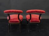 a pair of red upholstered chairs on a black background