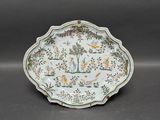 une assiette blanche ornée d'un motif représentant des oiseaux et des fleurs