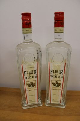 two bottles of liquor sitting on top of a wooden table