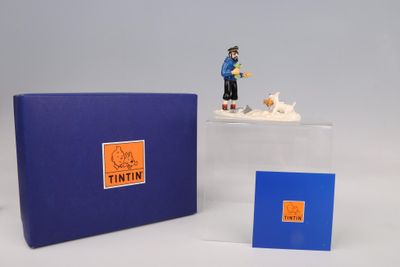 une petite figurine représentant un homme et un chien, dans une boîte