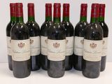 six bottles of red wine are lined up on a white surface