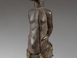 an image of a wooden statue of a man holding a knife
