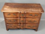 une commode ancienne avec un plateau en bois et des poignées en laiton