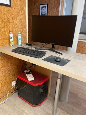 a computer desk with a keyboard and a monitor on it