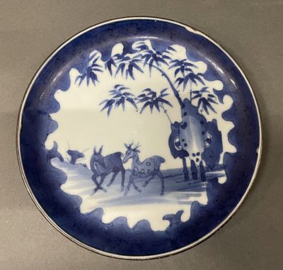 a blue and white plate with a picture of a man on a horse drawn carriage