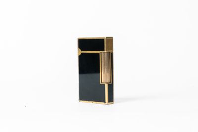 un briquet noir et doré posé sur une surface blanche