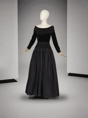 une photo d'un mannequin portant une robe noire dont l'encolure est ornée de perles