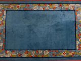 blue area rug with a border of flowers and leaves