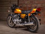 a yellow motorcycle parked in front of a brick wall
