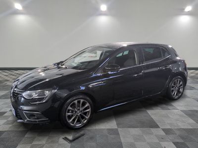 a black car is parked on a checkered floor in a garage