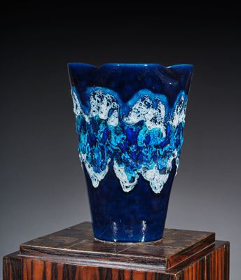 un vase bleu posé sur une caisse en bois
