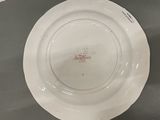 a white plate with a red design on it sitting on a table