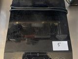 a black oven sitting on top of a stainless steel counter