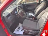 a red car with a steering wheel and a newspaper in the passenger seat