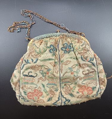 an old purse with a chain hanging from it ' s side on a table