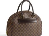 un sac à main marron et noir posé sur une surface blanche