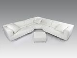 une photo d'un canapé modulable en cuir blanc accompagné d'un pouf