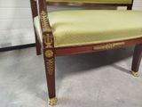 a chair with a green upholstered seat in a room