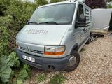 une camionnette argentée garée sur un parking en gravier
