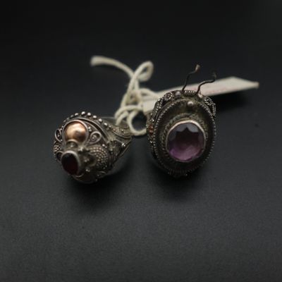 paire de boucles d'oreilles en argent ornées d'améthyste et de grenats sur un fond noir