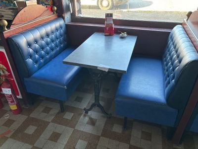 a blue booth with a table and two blue chairs