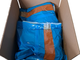 a cardboard box filled with blue and orange bags
