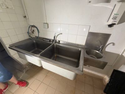 a woman standing in a kitchen with a sink and a dishwasher
