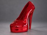 a red high heeled shoe that is sitting on a table