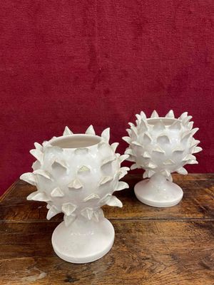 two white vases sitting on a wooden table