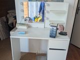 a white desk with a mirror and a phone on it