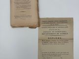 un vieux livre posé sur une table blanche, à côté d'une feuille de papier
