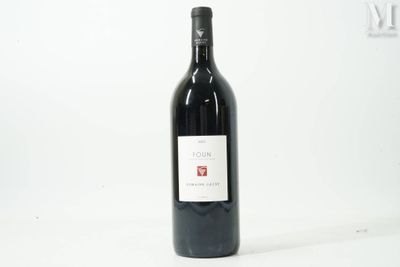 la bouteille de vin rouge est posée sur une surface blanche