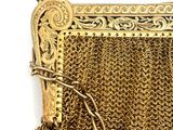 an old gold chain purse with a chain around it