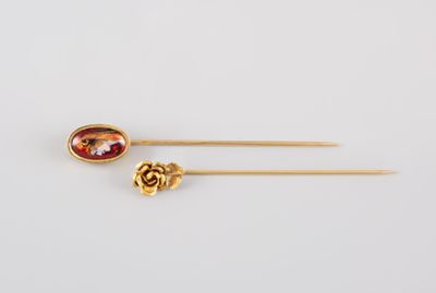 une paire d'épingles à cheveux dorées ornées d'une pierre rouge