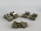 four army vehicles that are sitting on a white surface