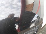 a reflection of a man in the mirror of a surfboard