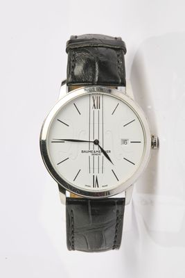 une montre noire et blanche posée sur une surface blanche