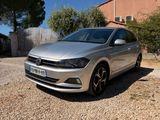 the silver volkswagen polo is parked in front of a house